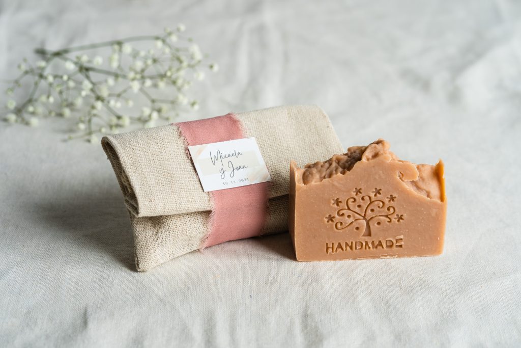 Jabón artesanal en bolsa de lino decorativa, ideal como regalo para bodas rústicas.