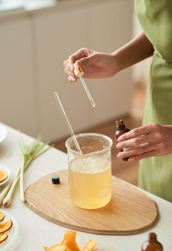 Woman using pipette to add oils into soap mixture